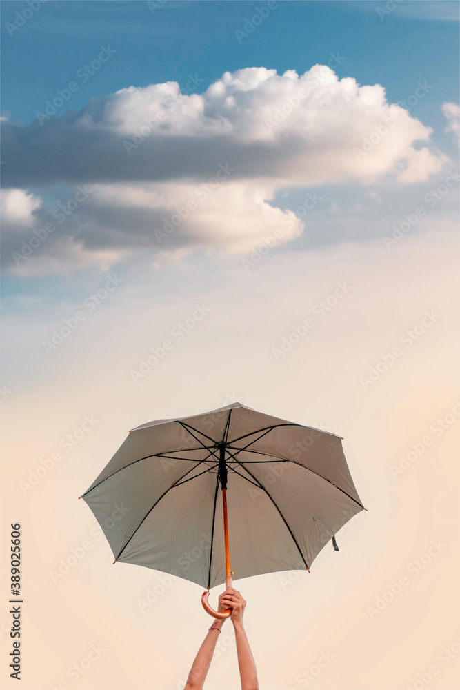A woman holding a large umbrella in the sky.