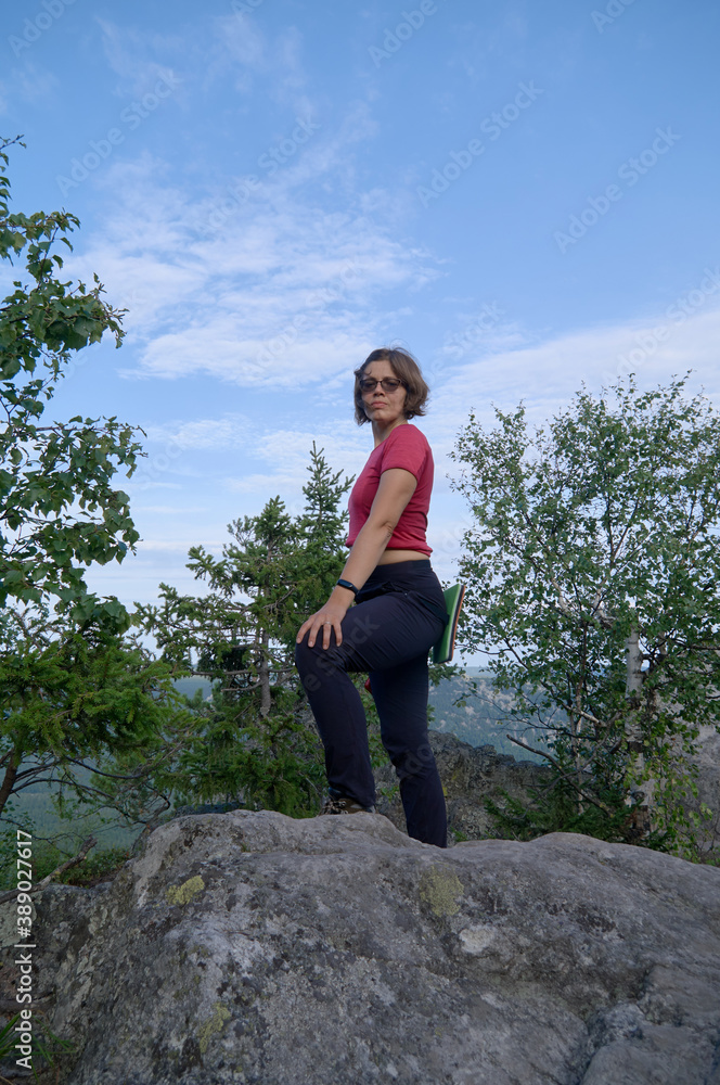 Female hiker standing at top of the rock