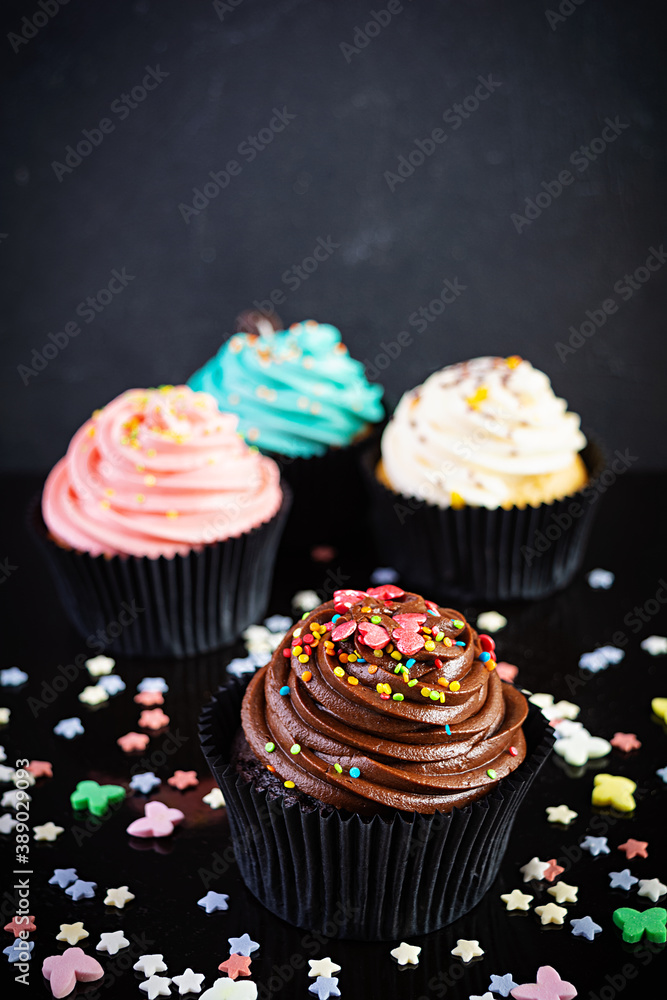 Tasty colorful cupcakes isolated on dark background. Delicious cupcake