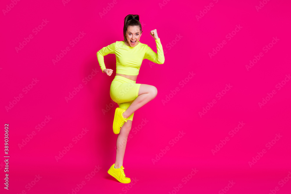 Full size profile photo of astonished young lady stand fists up yell dress sport suit sneakers isolated on pink color background