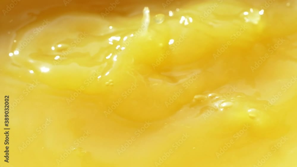 Macro orange fruit slice falling down into fresh orange juice drink, slow motion Macro orange fruit slice falling down into fresh orange juice drink, slow motion