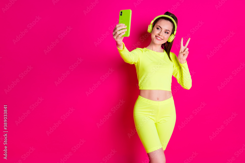 Portrait of her she nice attractive pretty charming cheerful cheery glad girl listening music taking selfie showing v-sign isolated bright vivid shine vibrant pink fuchsia color background Portrait of her she nice attractive pretty charming cheerful cheery glad girl listening music taking selfie showing v-sign isolated bright vivid shine vibrant pink fuchsia color background