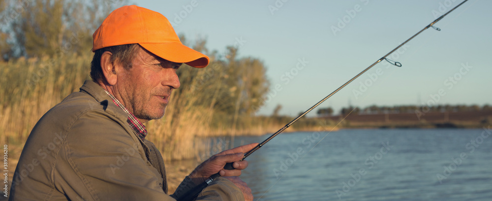 Fishing rod wheel closeup, man fishing with a beautiful sunset. Fishing rod wheel closeup, man fishing with a beautiful sunset.