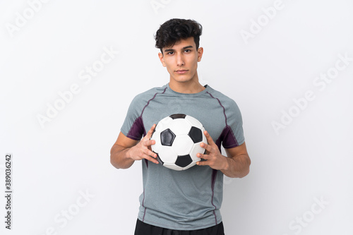 Young Argentinian man over isolated white background with soccer ball © luismolinero
