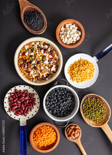 Top view flat lay of assortment of legumes on black tabletop