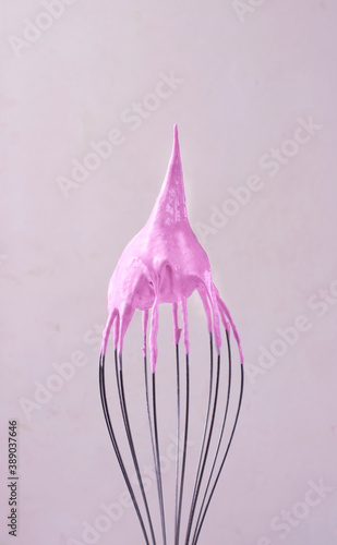 Pink marshmallow with stable peak on the balloon whisk. Cooking a dessert