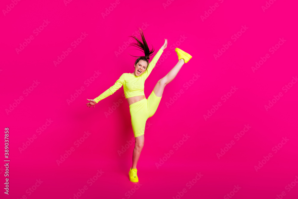 Full length body size photo of jumping high sportswoman shouting loudly keeping leg up isolated on bright pink color background