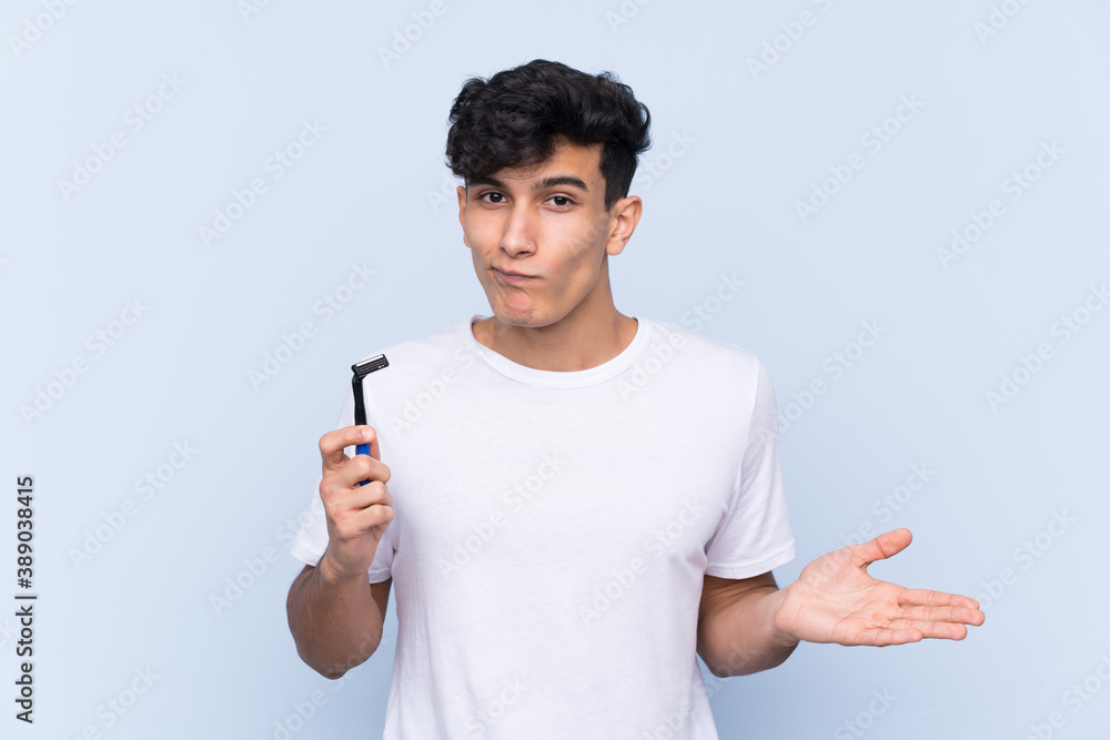 Man shaving his beard over isolated white background making doubts gesture while lifting the shoulders Man shaving his beard over isolated white background making doubts gesture while lifting the shoulders