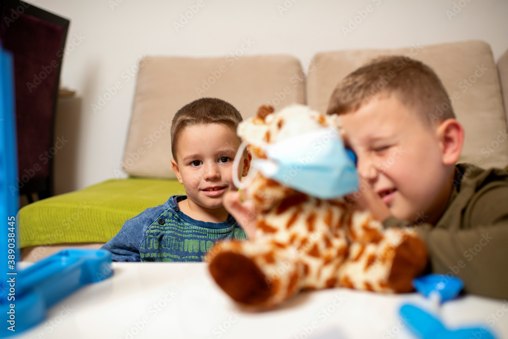 Children at home quarantine checking stuffed toy, for protection against viruses during coronavirus COVID-19 and flu outbreak. Children and illness disease concept. Children at home quarantine checking stuffed toy, for protection against viruses during coronavirus COVID-19 and flu outbreak. Children and illness disease concept.