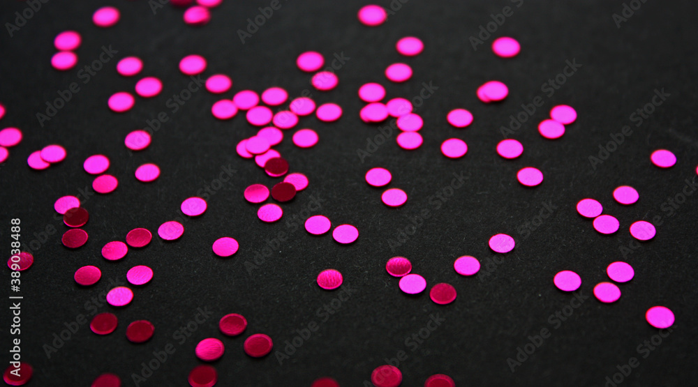 Vibrant glowing metallic circle confetti decoration on a black background. Glitter. Festive backdrop. Template.