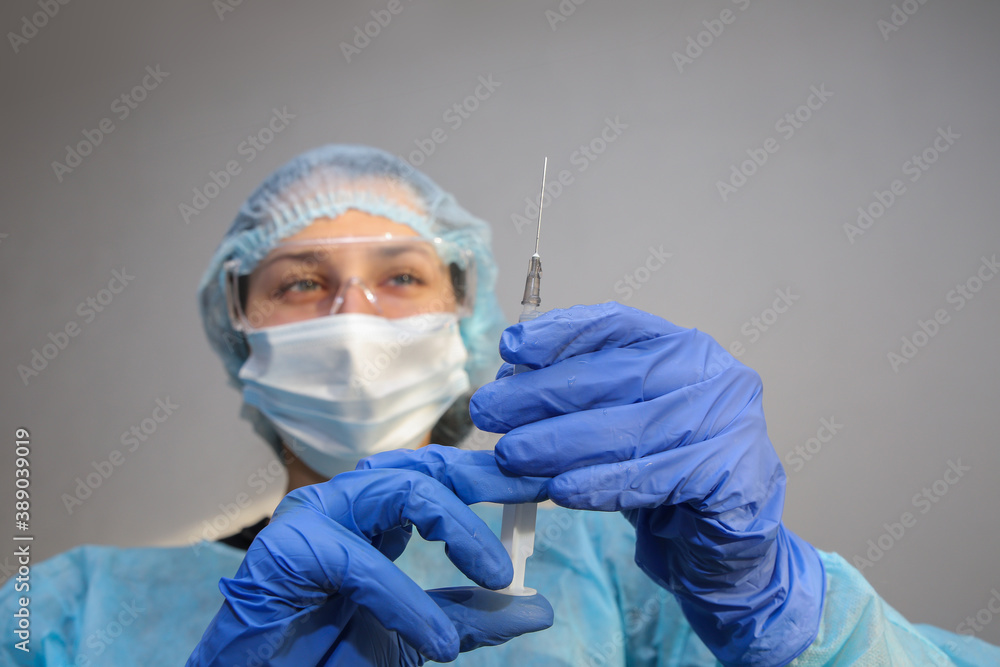young woman doctor nurse in a protective mask with a syringe in her hand young woman doctor nurse in a protective mask with a syringe in her hand