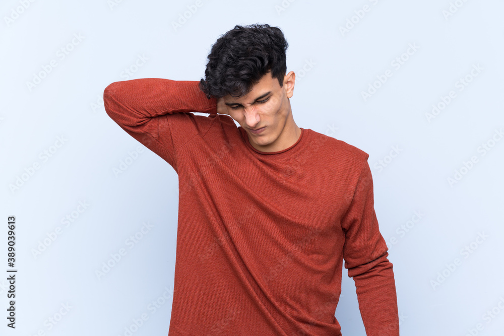 Young Argentinian man over isolated blue background with neckache Young Argentinian man over isolated blue background with neckache