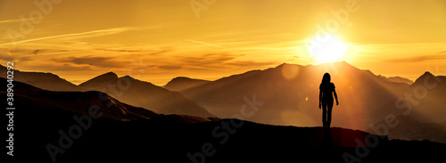 Frau betrachtet einen Sonneaufgang im Gebirge
