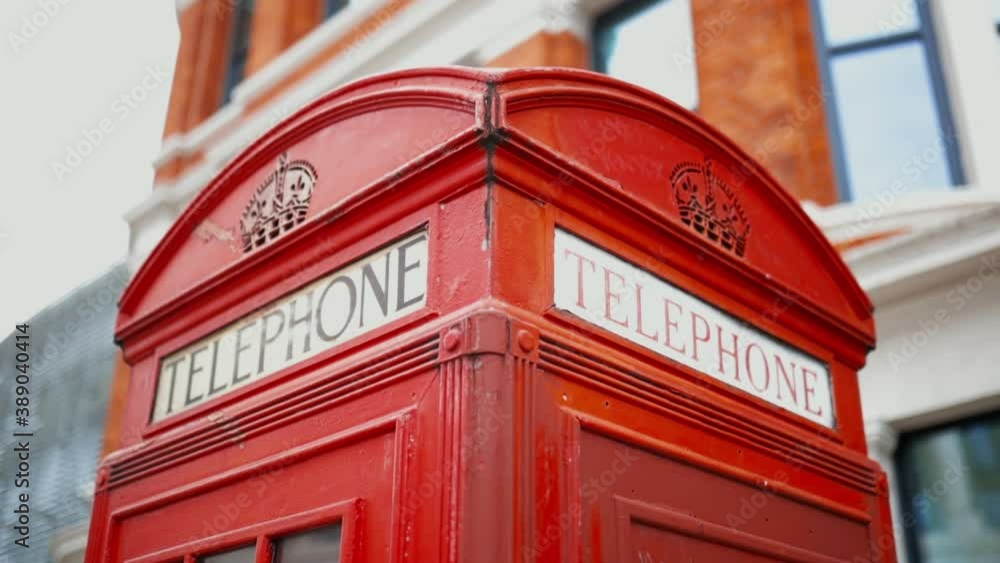 Top of a London telephone booth with a blurry brick building as background Top of a London telephone booth with a blurry brick building as background