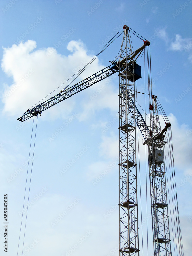 Two construction cranes against the sky Two construction cranes against the sky
