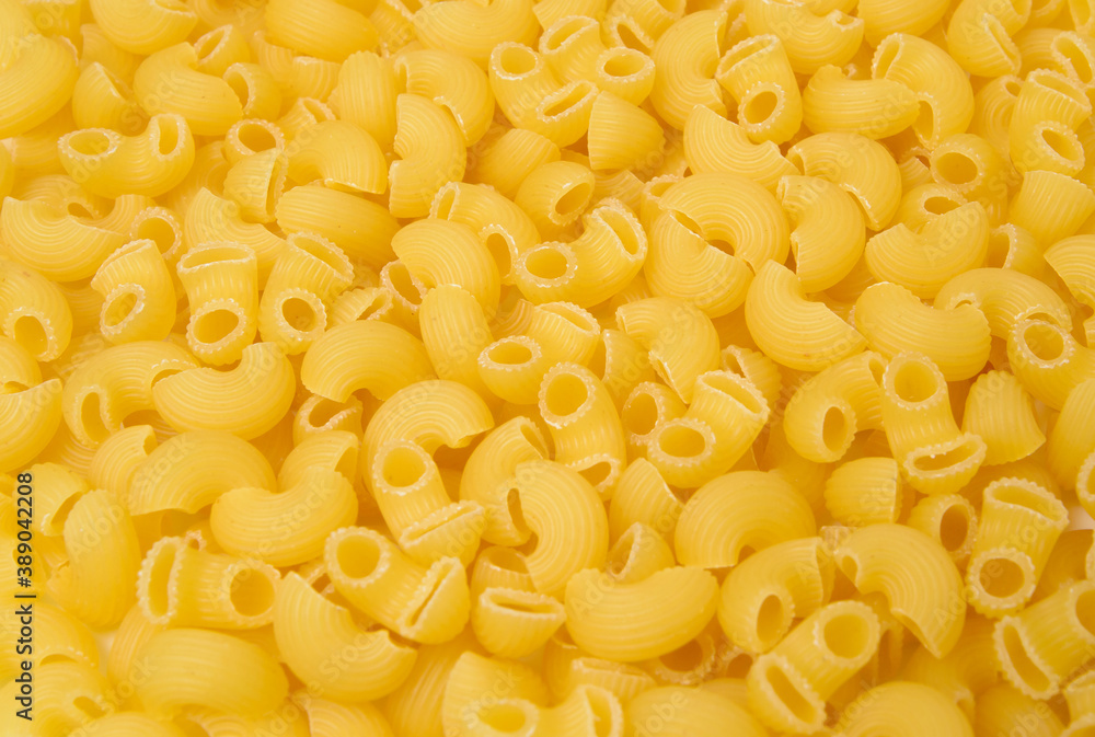 Background from macaroni pipa rigata. Raw, uncooked. Top view, close-up. Background from macaroni pipa rigata. Raw, uncooked. Top view, close-up.