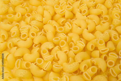 Background from macaroni pipa rigata. Raw, uncooked. Top view, close-up.