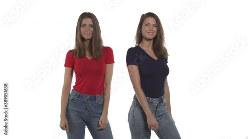 Funny Caucasian twin sisters doing hip swing move by bumping on buttocks each other. Isolated on white background