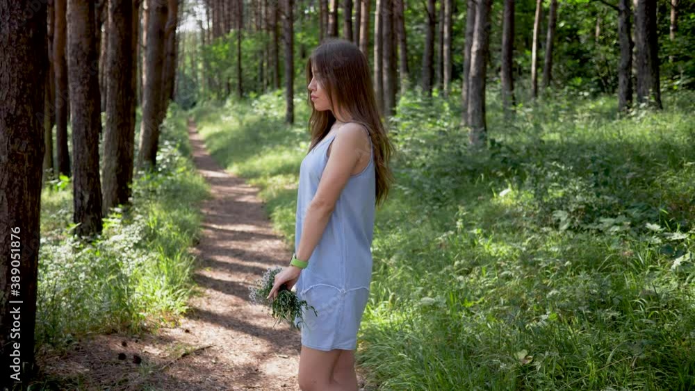 Romantic Girl With Bouquet Enjoying Summer In Park. Female holds Bouquet Of Wildflowers Daisies. Side view. Slow motion Romantic Girl With Bouquet Enjoying Summer In Park. Female holds Bouquet Of Wildflowers Daisies. Side view. Slow motion