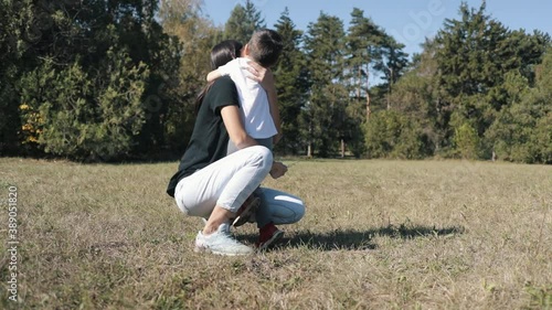 Idyllic Young Caucasian Girl With A Little Boy In A Park On A Meadow Hugging .Family Recreation Park