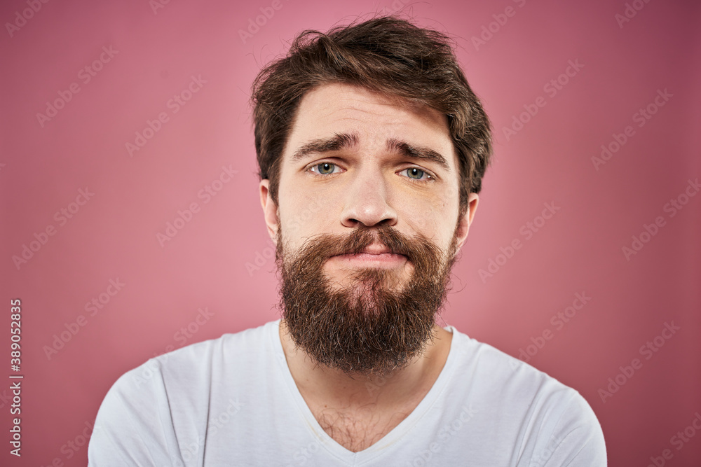 Fototapeta premium bearded man in white t-shirt emotions displeased facial expression studio pink background