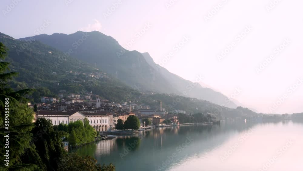 Drone view of Lake Iseo at sunrise, on the left the city of Lovere which runs along the lake,Bergamo Italy. Drone view of Lake Iseo at sunrise, on the left the city of Lovere which runs along the lake,Bergamo Italy.