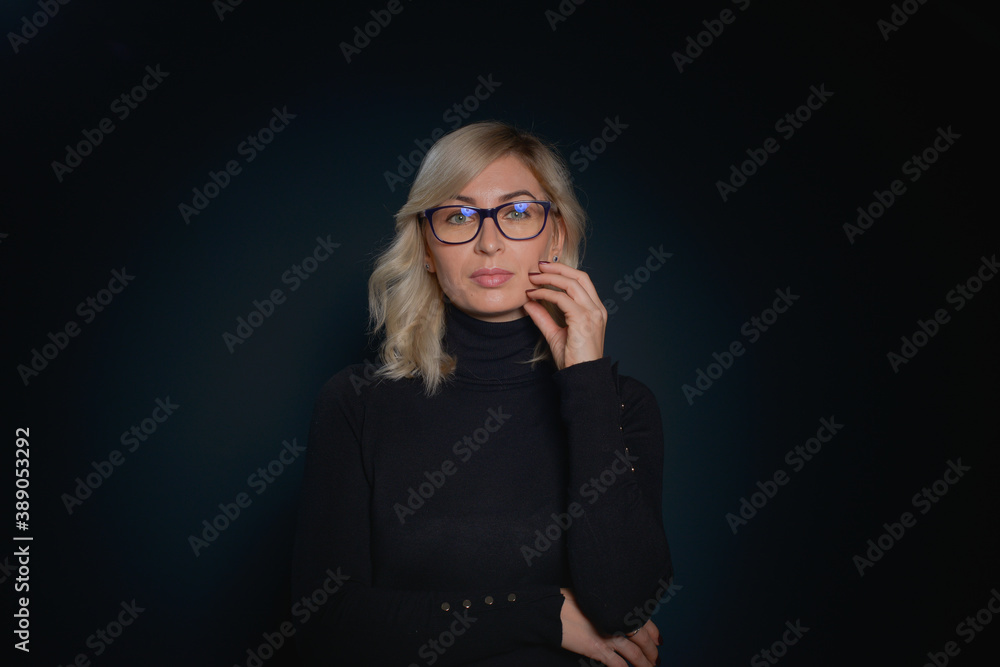 Beautiful young blonde woman with blue eyes isolated on back wearing a black top Beautiful young blonde woman with blue eyes isolated on back wearing a black top