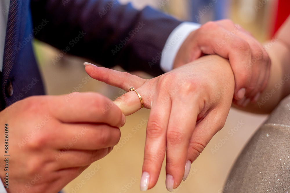close-up of the groom puts the ring on the bride