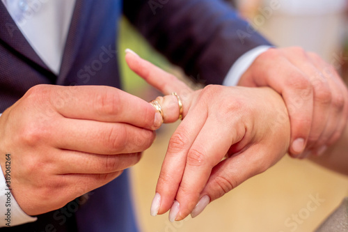 close-up of the groom puts the ring on the bride