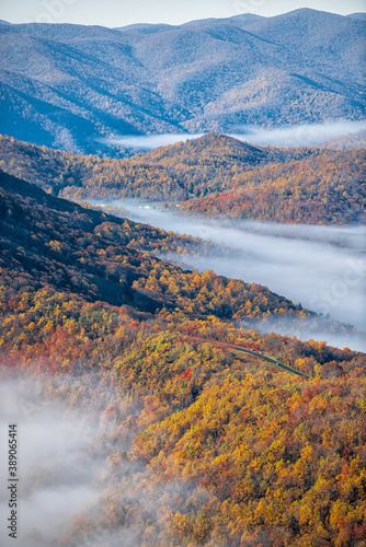Devil's Knob Overlook vertical view at Wintergreen resort town with Blue Ridge parkway road highway in mountains with autumn fall clouds mist fog covering peak high angle view