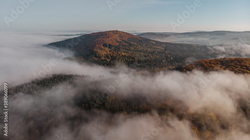 Aerial view of morning foggy landscape. Fall autumn peaceful scenery. Misty calm atmosphere. Drone photo of Czech mountain Velky Blanik. Trees in fog. Fairy tale land.Meditation dreamy concept.