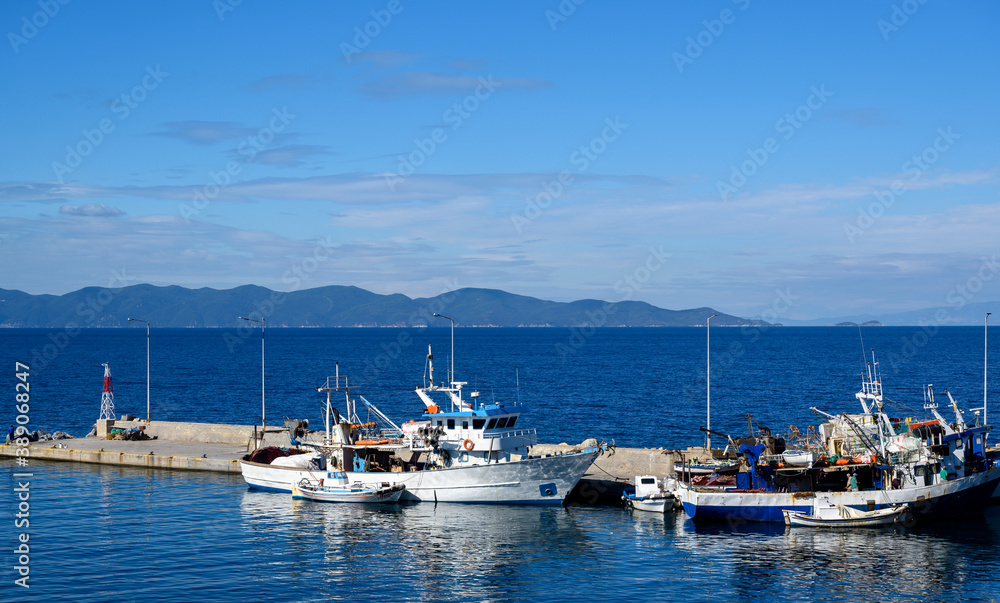 Boats in the port of Nea Roda on blue sea water