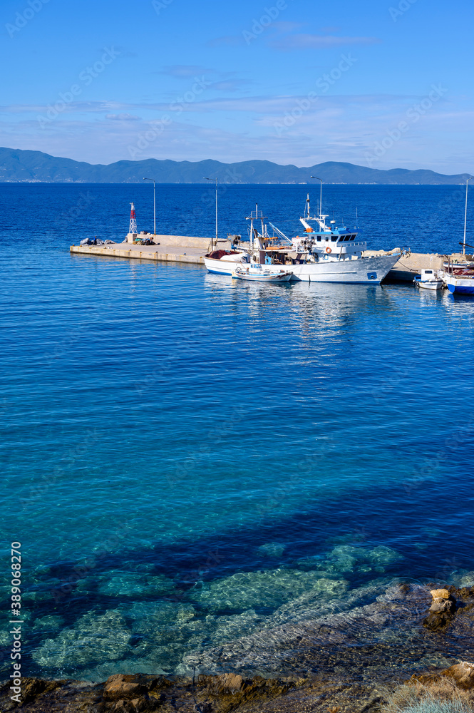 Boats in the port of Nea Roda on blue sea water