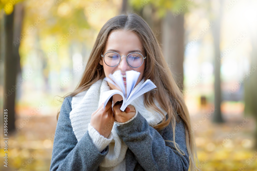 A young beautiful girl walks in the park on a sunny autumn day. A young beautiful girl walks in the park on a sunny autumn day.