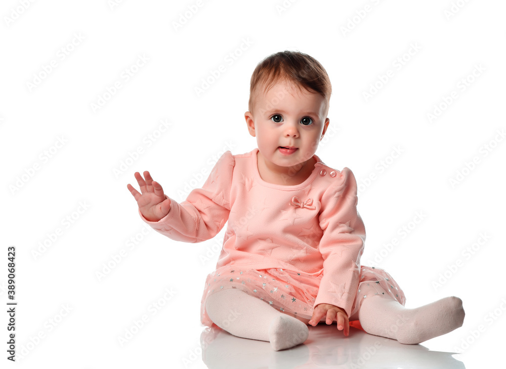 Adorable little baby girl smiling, sitting on the floor, studio shot, isolated on white Adorable little baby girl smiling, sitting on the floor, studio shot, isolated on white