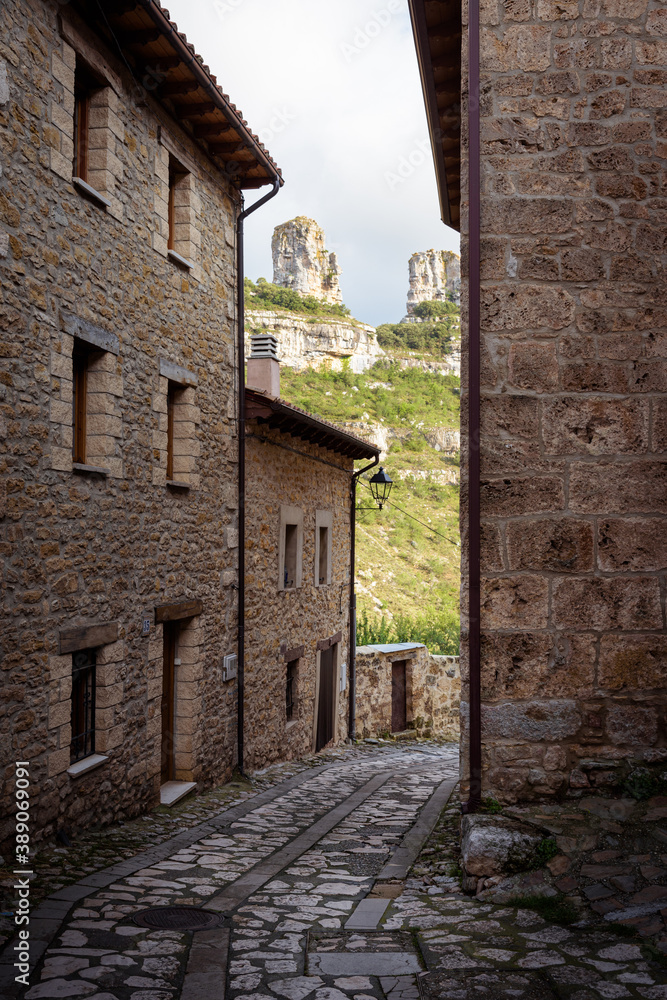 Traditional stone houses on a cobbled street with the natural cliff surrounding Orbaneja del Castillo, Burgos, Spain