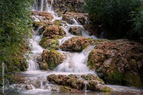 Small waterfall among the vegetation pouring water into a lake, Orbaneja del Castillo, Burgos, Spain © JMDuran Photography