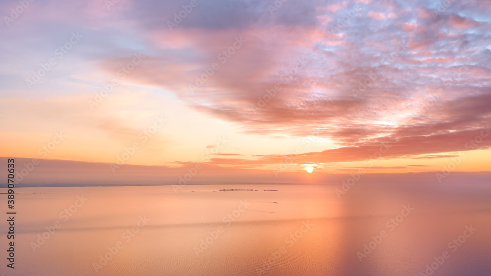 Calm amber colored sea and sky at sunset