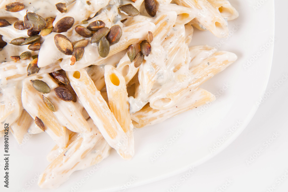 Pasta with blue cheese and cream sauce, sprinkled with roasted pumpkin seeds