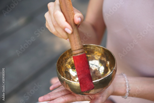 Meditation with vibrations from the bowl in the lotus position. Nature yoga theme hands and bronze utensils. soul music on an instrument