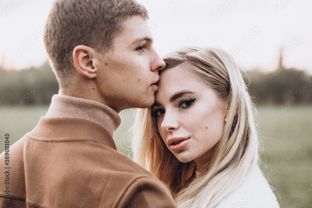 Beautiful young couple in autumn walks with dogs, pomeranian, in the park Beautiful young couple in autumn walks with dogs, pomeranian, in the park