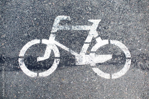 White bicycle sign on asphalt road, close up. City cycling concept