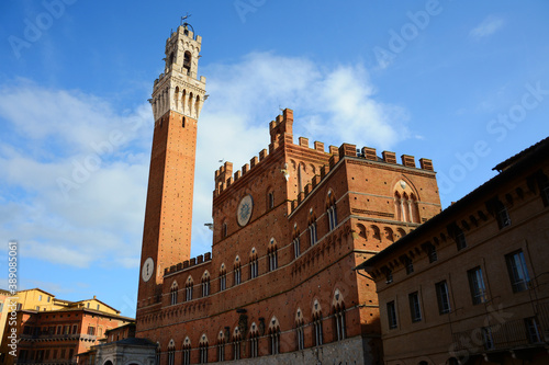 Siena tower in Tuscany, Italy. Red brick facade and blue sky. Winter time. 