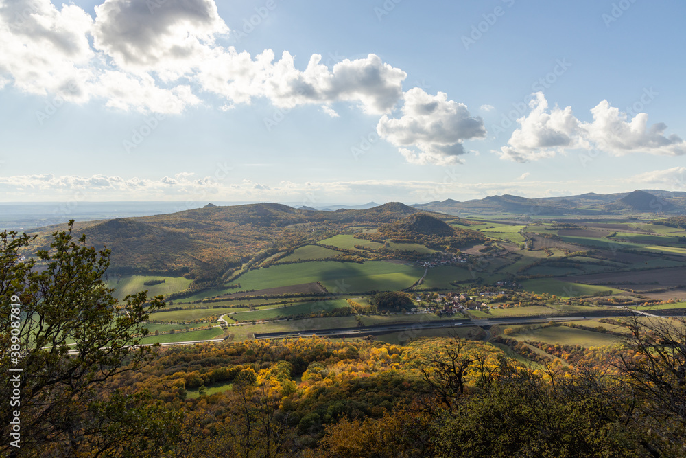 Autumn nature view from mountain Lovos to the horizont with hills and mountains and cloudy sky with trees in foreground