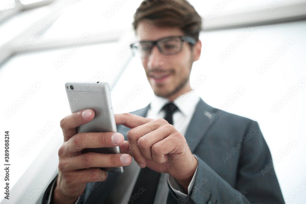 Businessman looking at mobile phone in office Businessman looking at mobile phone in office