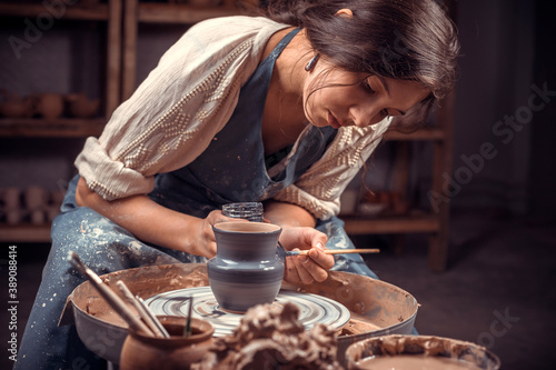 Beautiful ceramist working with pottery at the ceramic workshop. Making pottery. photo