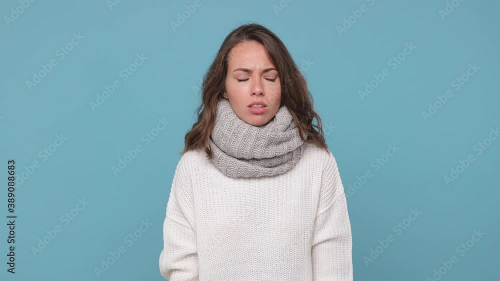 Tired smiling young brunette woman in sweater scarf isolated on blue background studio. Healthy lifestyle ill sick disease treatment cold season concept. Hold medication tablets pills looking excited Tired smiling young brunette woman in sweater scarf isolated on blue background studio. Healthy lifestyle ill sick disease treatment cold season concept. Hold medication tablets pills looking excited