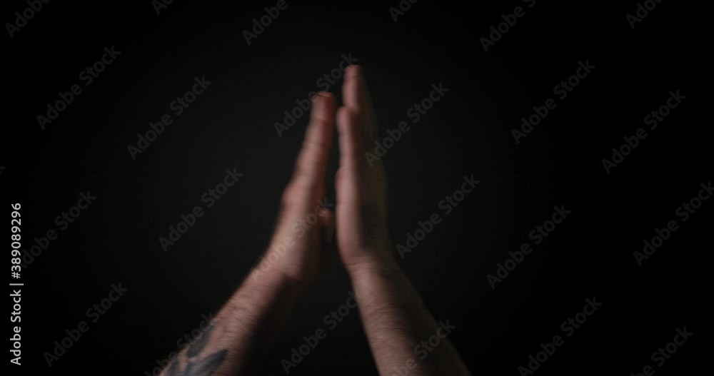 Male hands clapping against a black background. Male hands clapping against a black background.