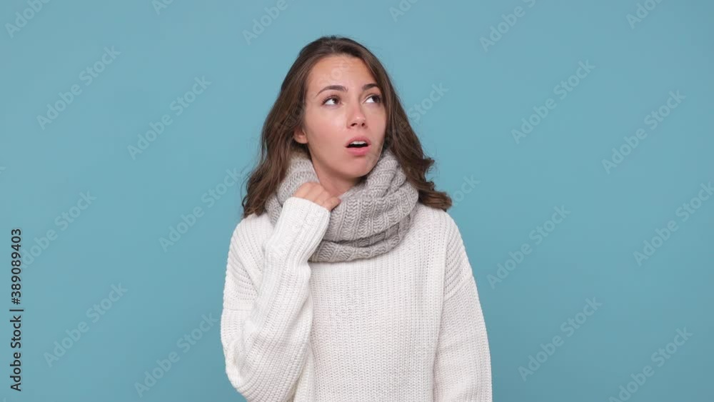 Tired young woman in sweater gray scarf isolated on pastel blue background studio. Healthy lifestyle ill sick treatment cold season concept. Coughing covering mouth with hands put hand on head nose Tired young woman in sweater gray scarf isolated on pastel blue background studio. Healthy lifestyle ill sick treatment cold season concept. Coughing covering mouth with hands put hand on head nose