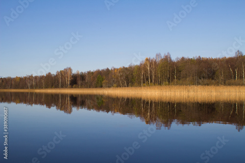 The autumn forest is reflected in the lake water.The concept of a private holiday. Horizontal orientation © iritetereva